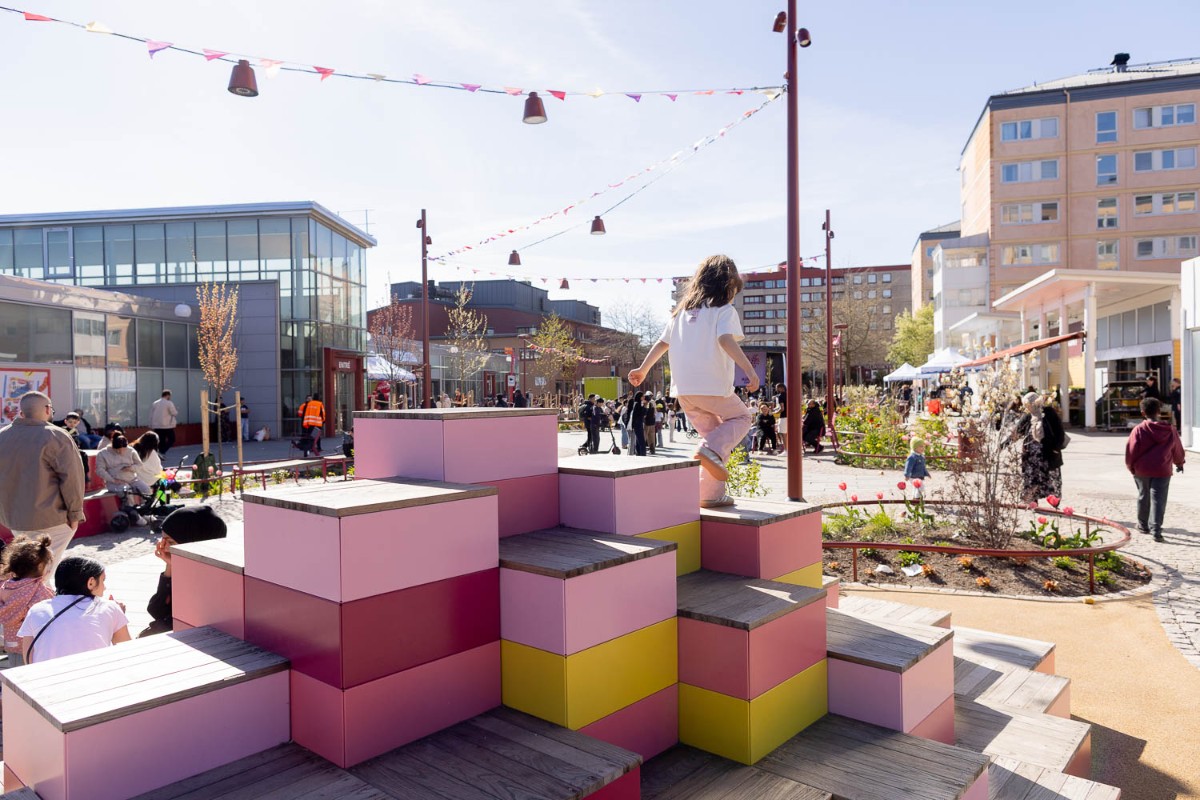BArn som leker på klossar i ett soligt Hjällbo Centrum